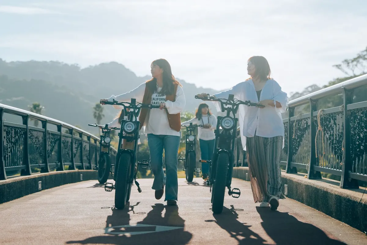 橋の上で E-BIKE を押して歩く4人