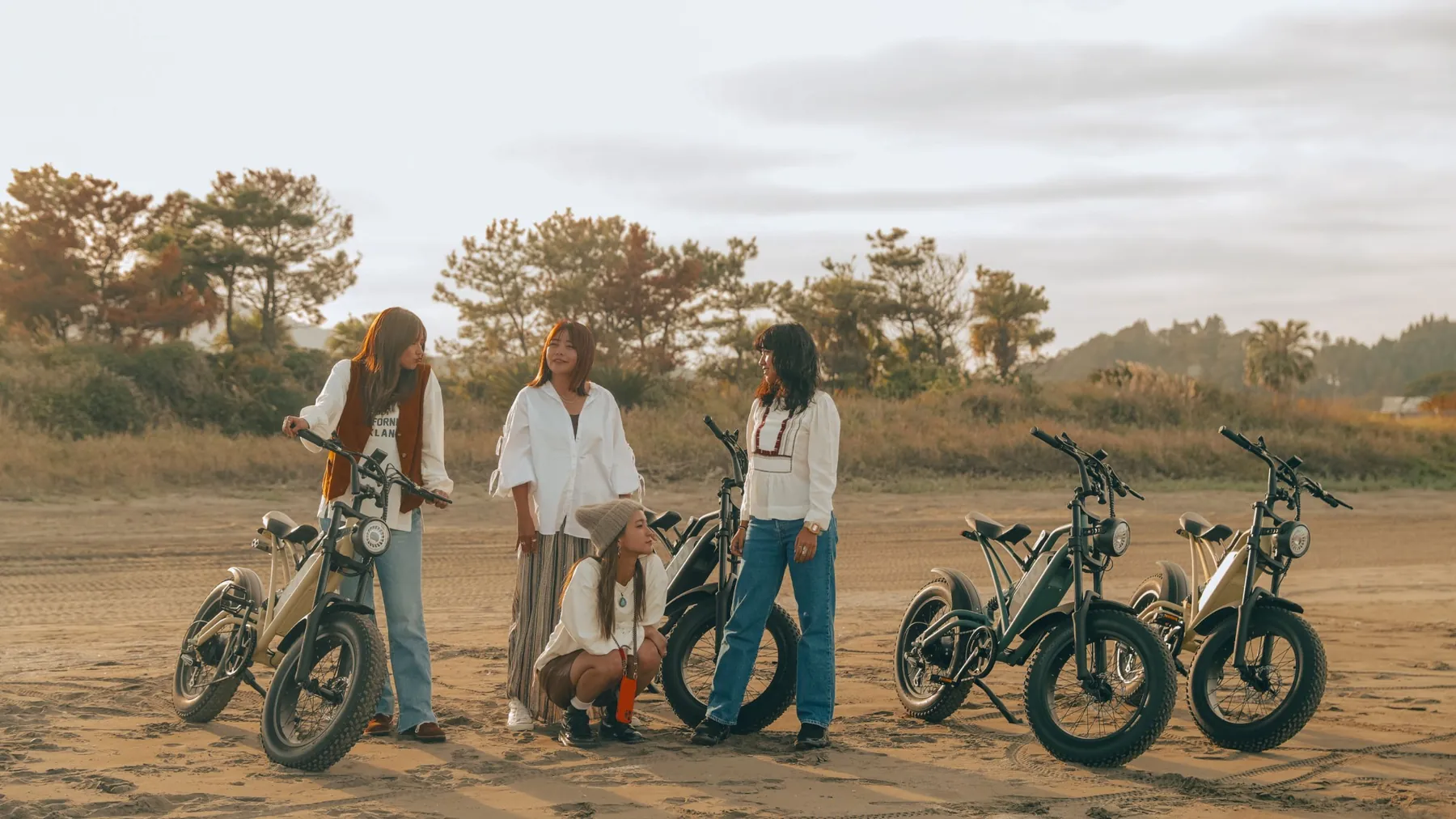 夕暮れのビーチに E-BIKE を停めて語らう4人