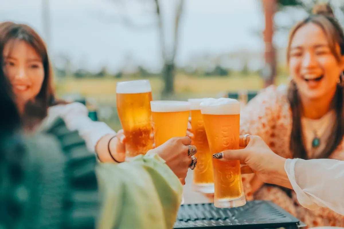 ビールのグラスを掲げて乾杯するメンバー