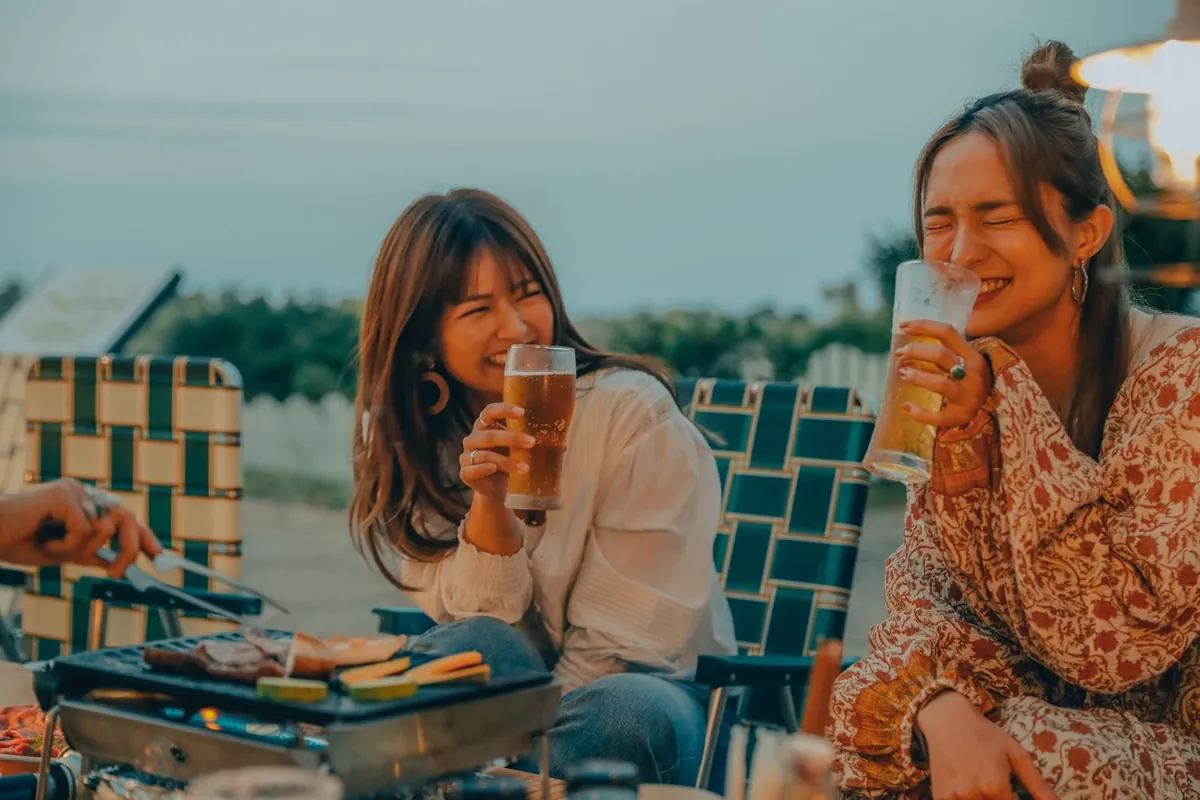グリルを囲んでビールを飲むメンバー