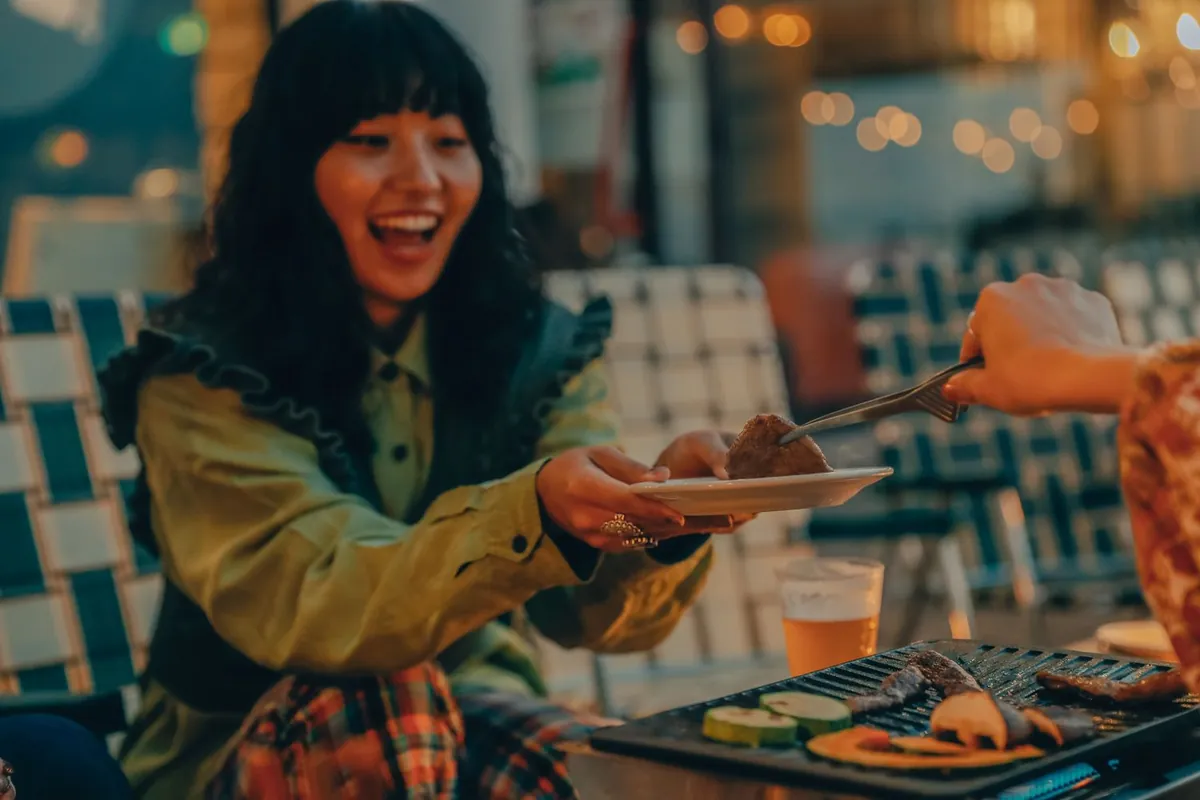 焼き上がった料理を取り分けるメンバー