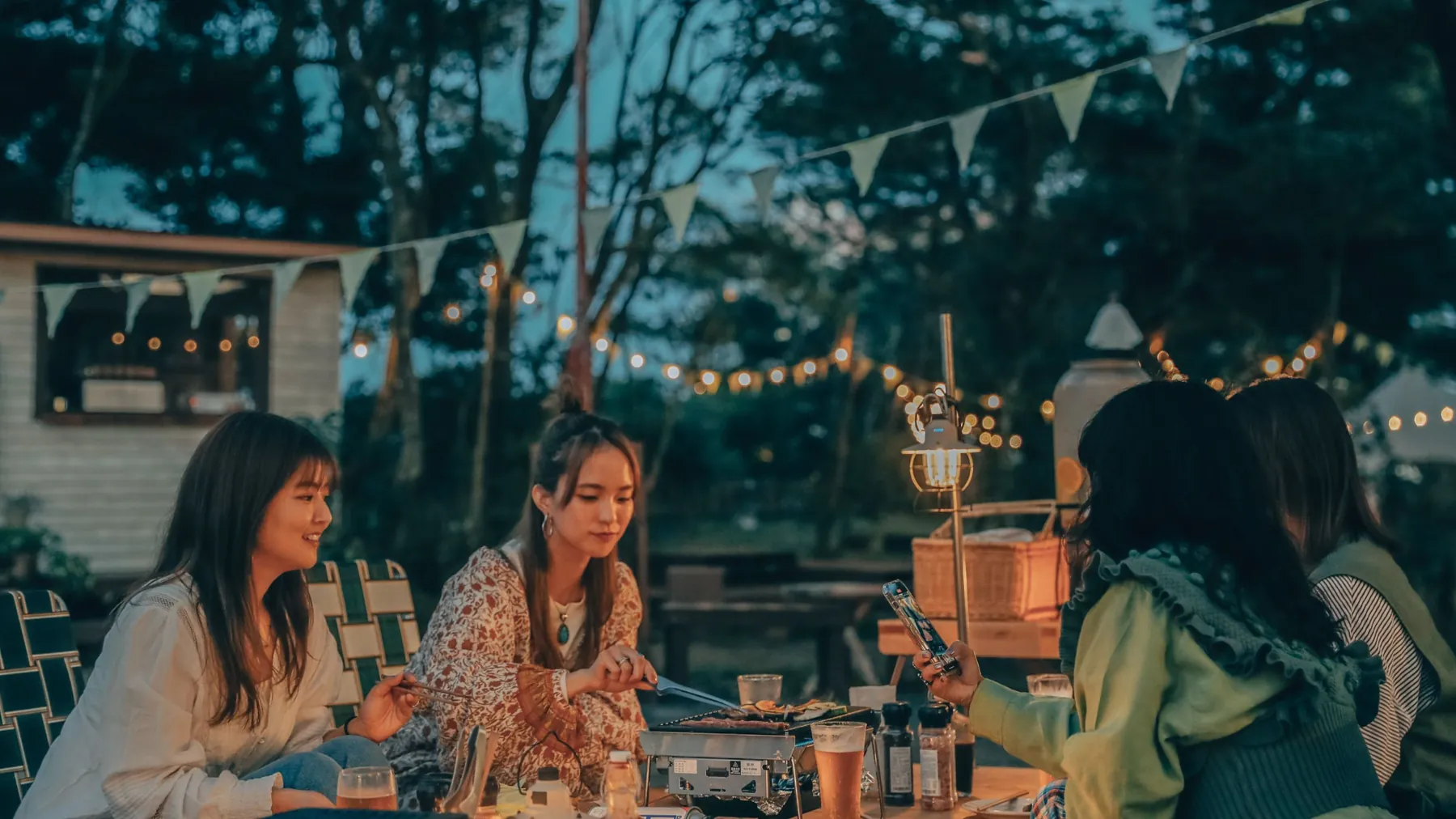 灯りをともした BBQ&BEER TERRACE で食事を楽しむメンバー